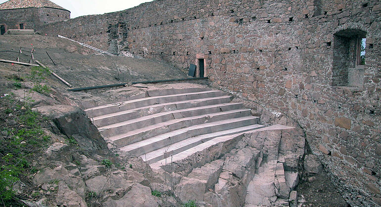 Tribuna in un cortile interno & passaggio nella roccia